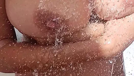 Büyük memeli ateşli seksi orta yaşlı seksi kadın yaz güneşinde serinlemek için açık havada duş alıyor.