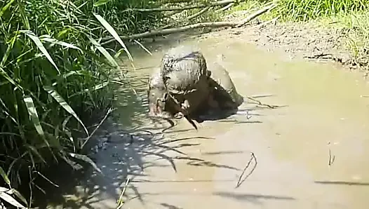 Çamurda oynayan çıplak adam