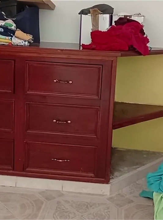 Tombul kız odayı topluyor ve kıyafetlerini katlıyor
