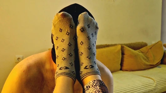 Çizmelerden sonra bacak ve ayak fetişi. Dominatrix kölenin çizmelerini çıkarmasına, terli çoraplarını koklamasına, ayaklarını öpmesine izin veriyor