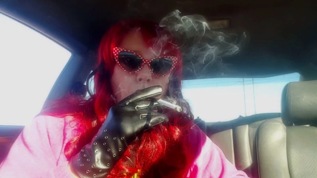 Leathergloves giyen olgun kızıl saçlı -holder arabada sigara içiyor vs120