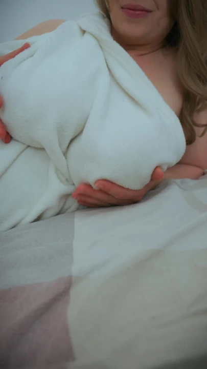 Orta yaşlı seksi kadın beyaz battaniye içinde kraliçe gibi davranıyor. Biri ona o göğüslerin güzel olduğunu söylemeli