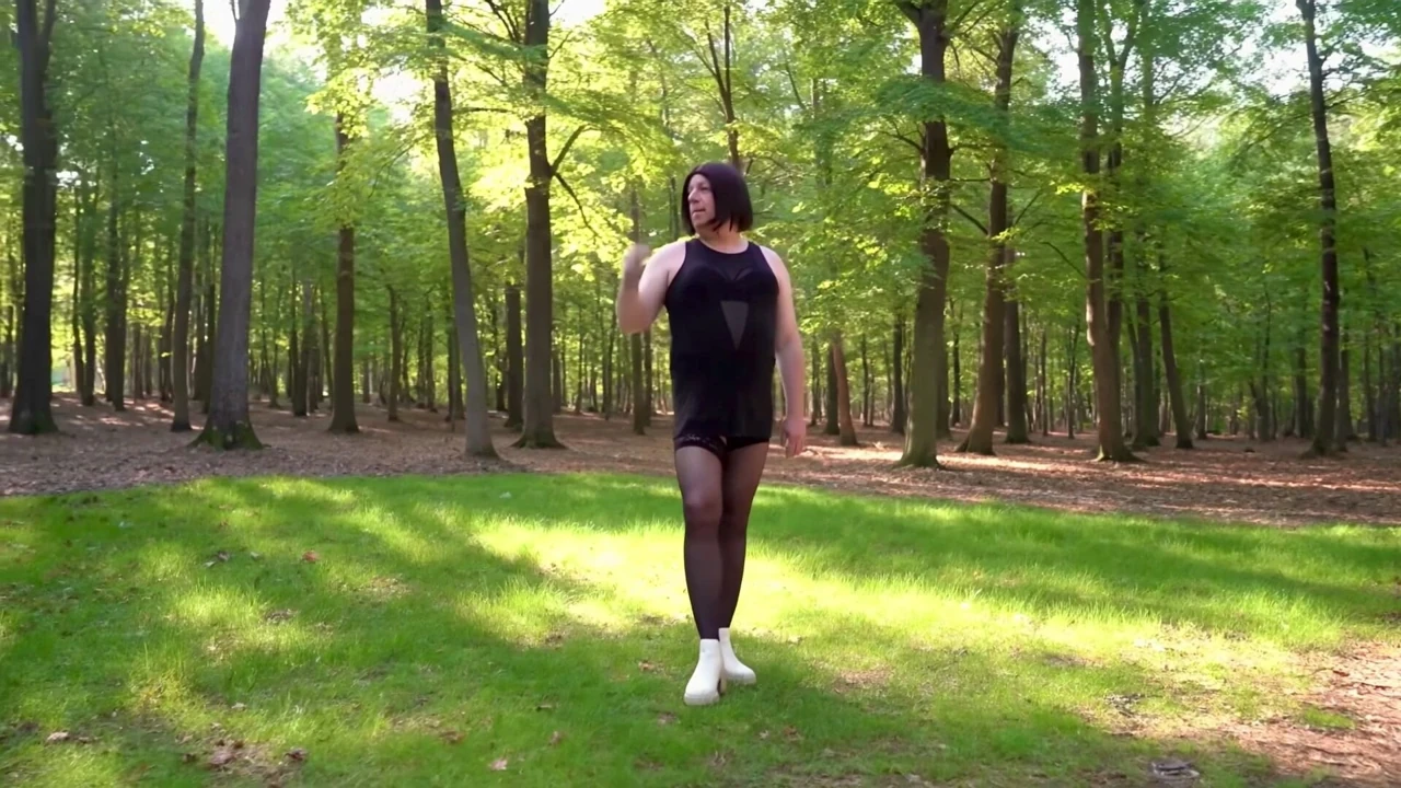 Seksi siyah örgülü mini elbiseli Nicki crossdress, hold-ups ve chelsea çizmeler ormanda (KI)