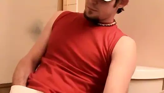 Sapık genç adam sigara içerken aletiyle oynuyor.