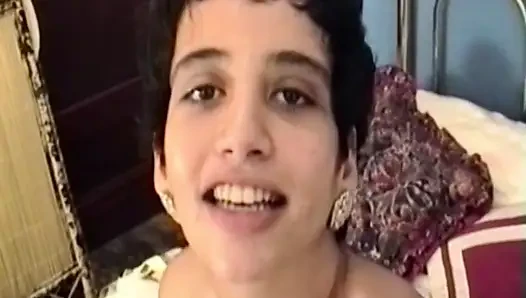 Esmer kadın yatakta soyunuyor ve soyunuyor