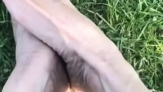 Melove yeşil çimlerde seksi küçük ayaklarını gösteriyor