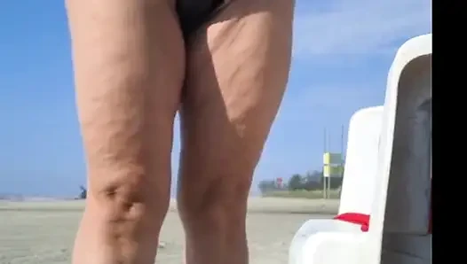 Hot crown sunbathing on the beach in transparent micro bikini