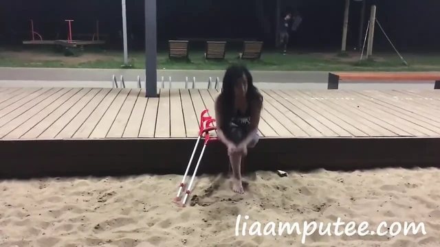 Sahilde koltuk değneği olan ampute kadın