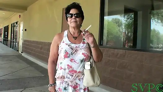 Genç erkek avcısı iri güzel kadın sigara içiyor ve pozlar atıyor