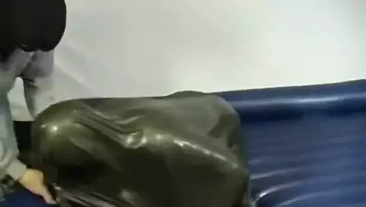 Yeşil bir lateks çanta içinde mücadele eden kadın