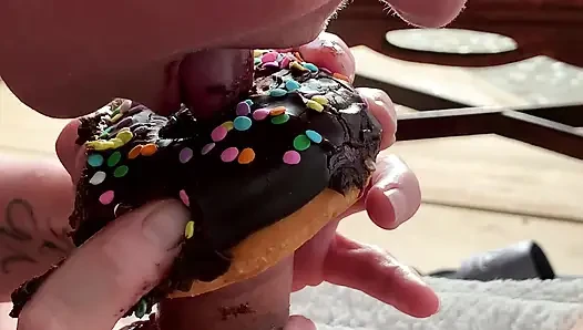 Siyah çikolatalı yarak yiyor döl kaplı çörek ve sprinkles