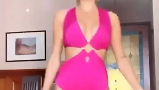 Pembe mayo giyen sarışın kız podyumda yürüyor