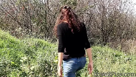 Kavanoza işiyor, yağmur montuna ve bir tepenin üstüne işiyor - derleme