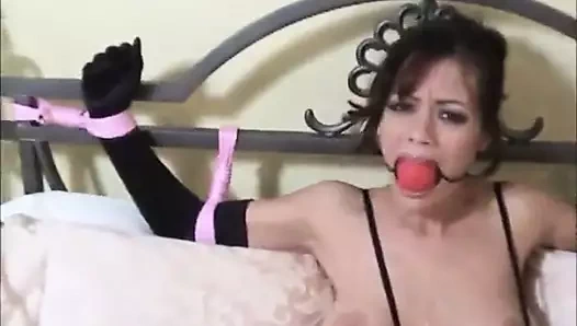 Frau mit Ball Gagg bang ans Bett geffesselt