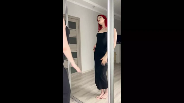 Uzun siyah dar elbiseli seksi kızıl saçlı dans ediyor