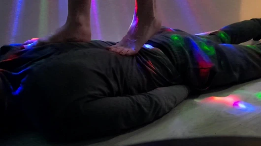 Bir kölenin vücudunu çiğnemek. dominatrix nika çıplak ayakla kölenin sırtında yürüyor.