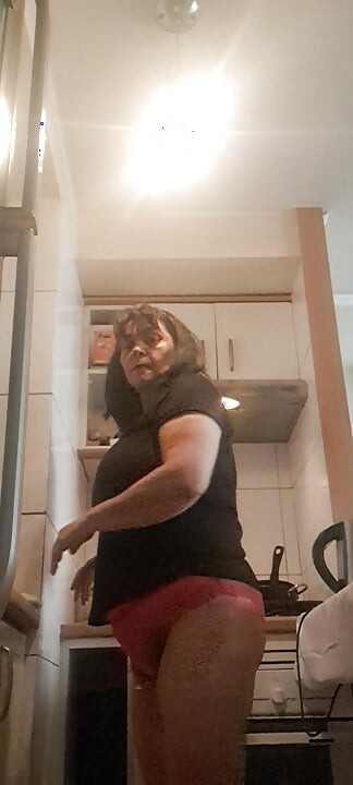 Orta yaşlı seksi kadın külotla bulaşık yıkıyor