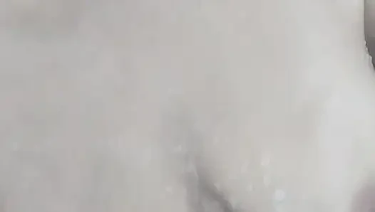 Ateşli olgun kadın banyoda rahatlıyor ve duşun altında köpükle mastürbasyon yapıyor