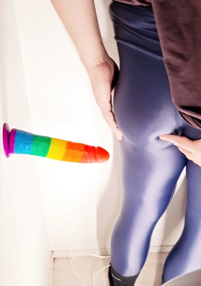 Büyük oyuncakla parlak tayt içinde keyif alan crossdresser