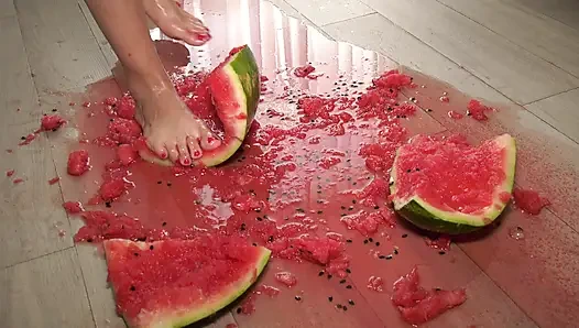 İri göğüslü orta yaşlı seksi kadın ayaklarını sunuyor ve karpuzla oynuyor