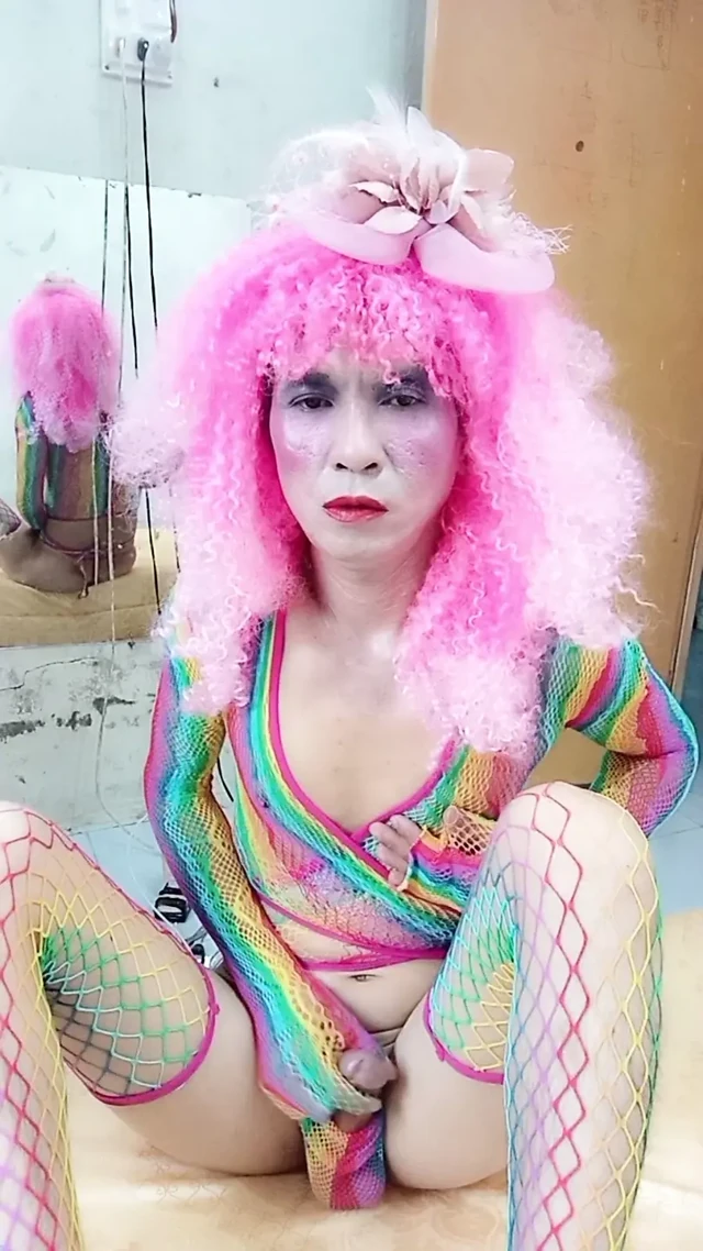 Transgender Le seksi kıyafetler giyiyor ve yapay göğüslerle seks kupaları oynuyor.
