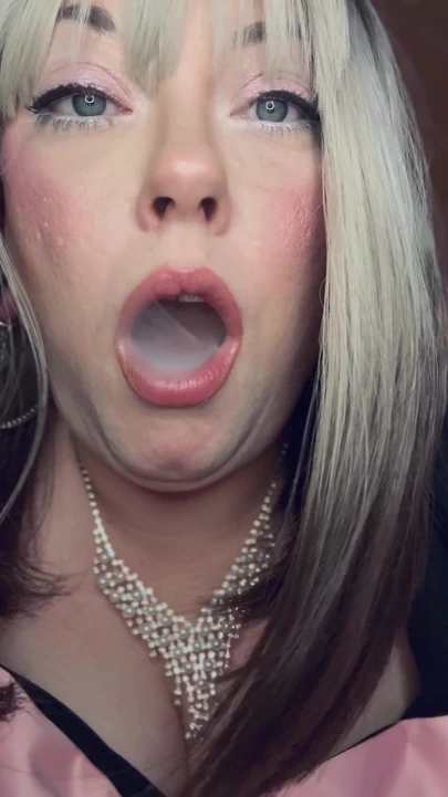 İri güzel kadın sarışın Tina Snua halkalı saten eldivenlerle tutacağıyla ince bir sigara içiyor | Klip 1