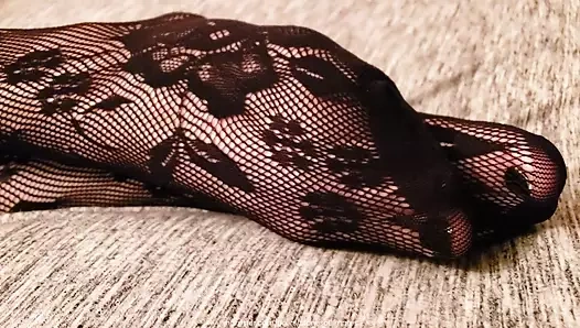 Evli kadın yatakta uzanıyor, külotlu çorapla bacaklarını, ayaklarını ve götünü gösteriyor