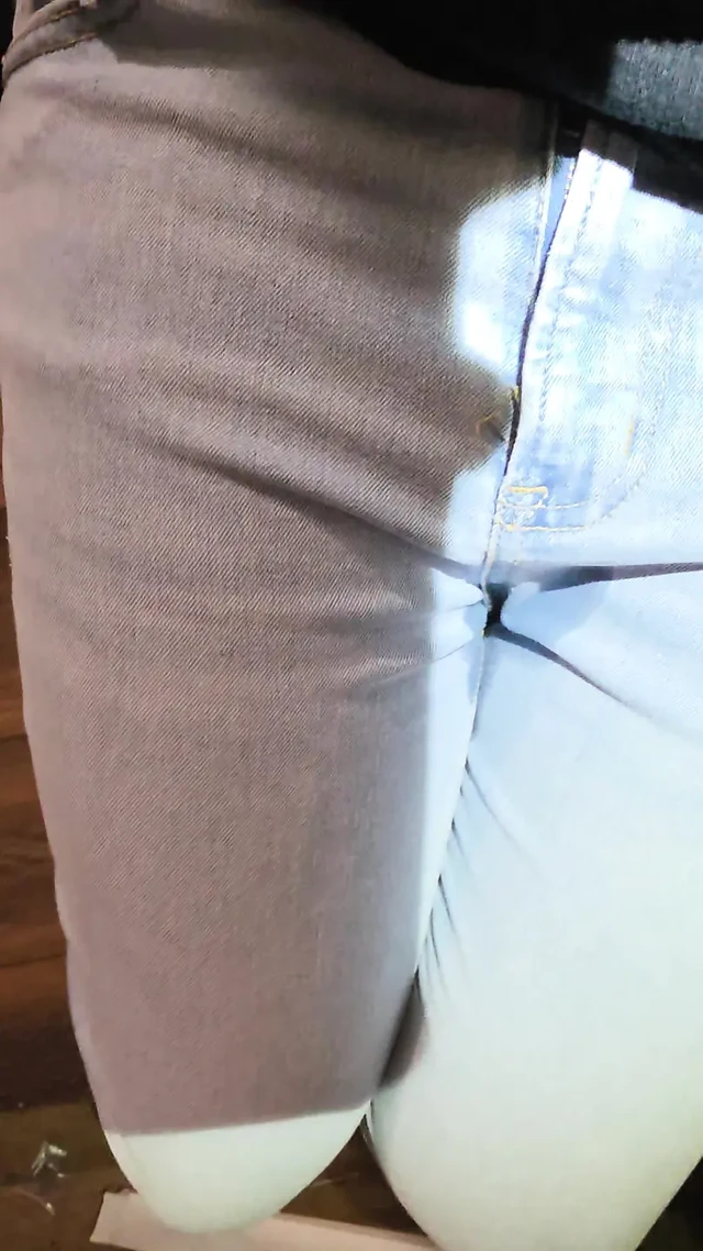 Desperately trying to hold but letting it all out in female light wash jeans