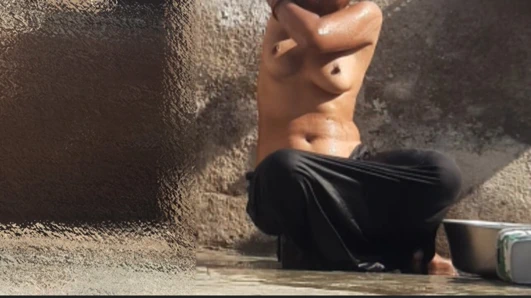 Indian sister-in-law is bathing in the open courtyard of the house, putting a finger in her burrow and rubbing the body, sister-in-law is washing the bathroom.