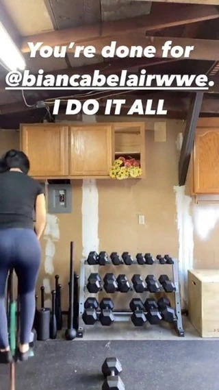 Wwe - bir pogo çubuğunun üzerinde zıplayan ve bir dambıl kaldıran bayley