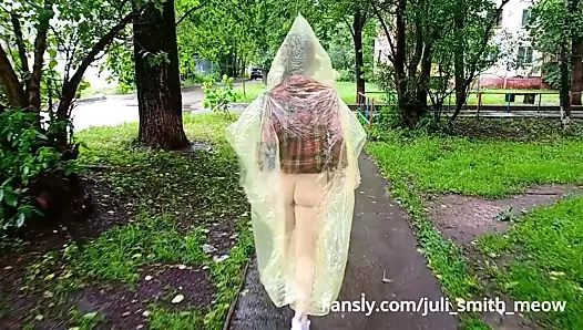 Şehir sokaklarında göğüsleri ve kıçı yanıp sönen yağmurluklu kız