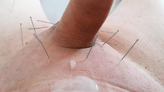 Bacaklara ve skrotuma iğneler ve boşalana kadar penise masaj yapıyor