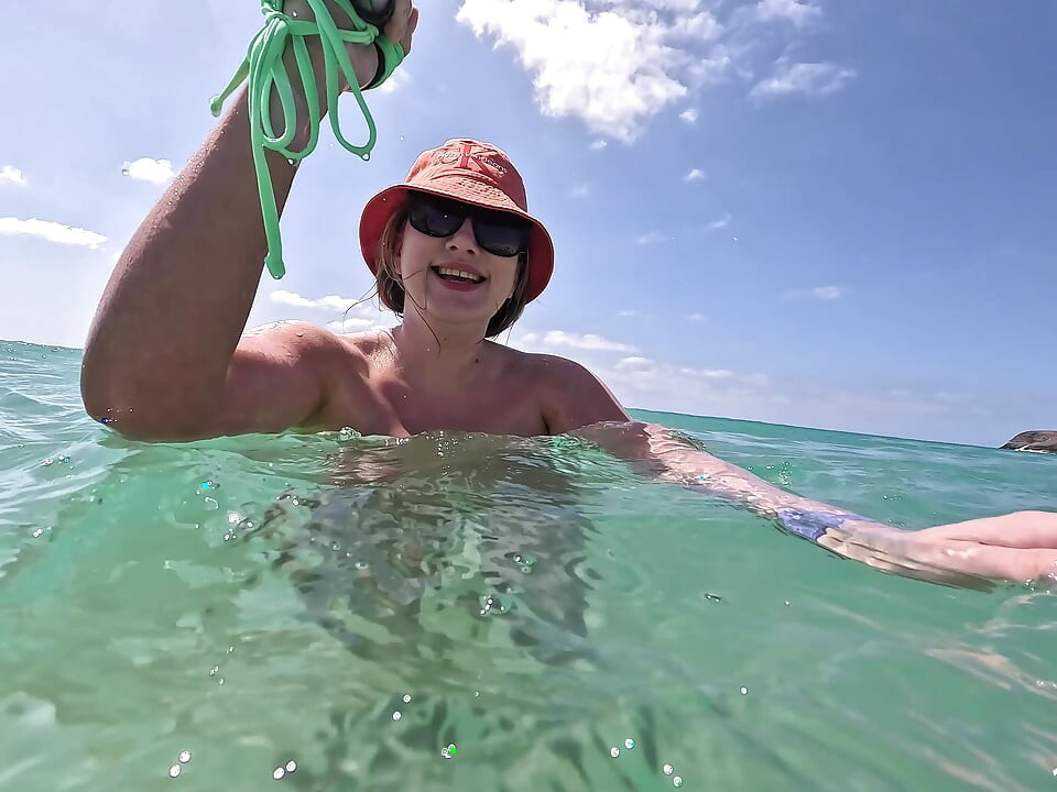Yaramaz sarışın açık havada okyanusa işiyor ve su altında yüzüyor