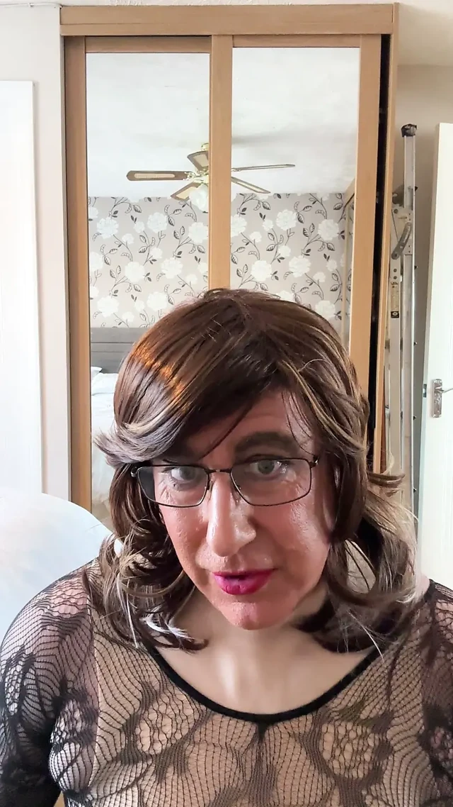 Seksi çapraz giyinmiş dantel şeffaf bodystocking giyiyor ve mastürbasyon yapıyor.