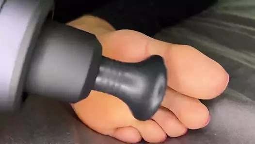 Zenci kız ayaklarına masaj silahıyla masaj yapıyor