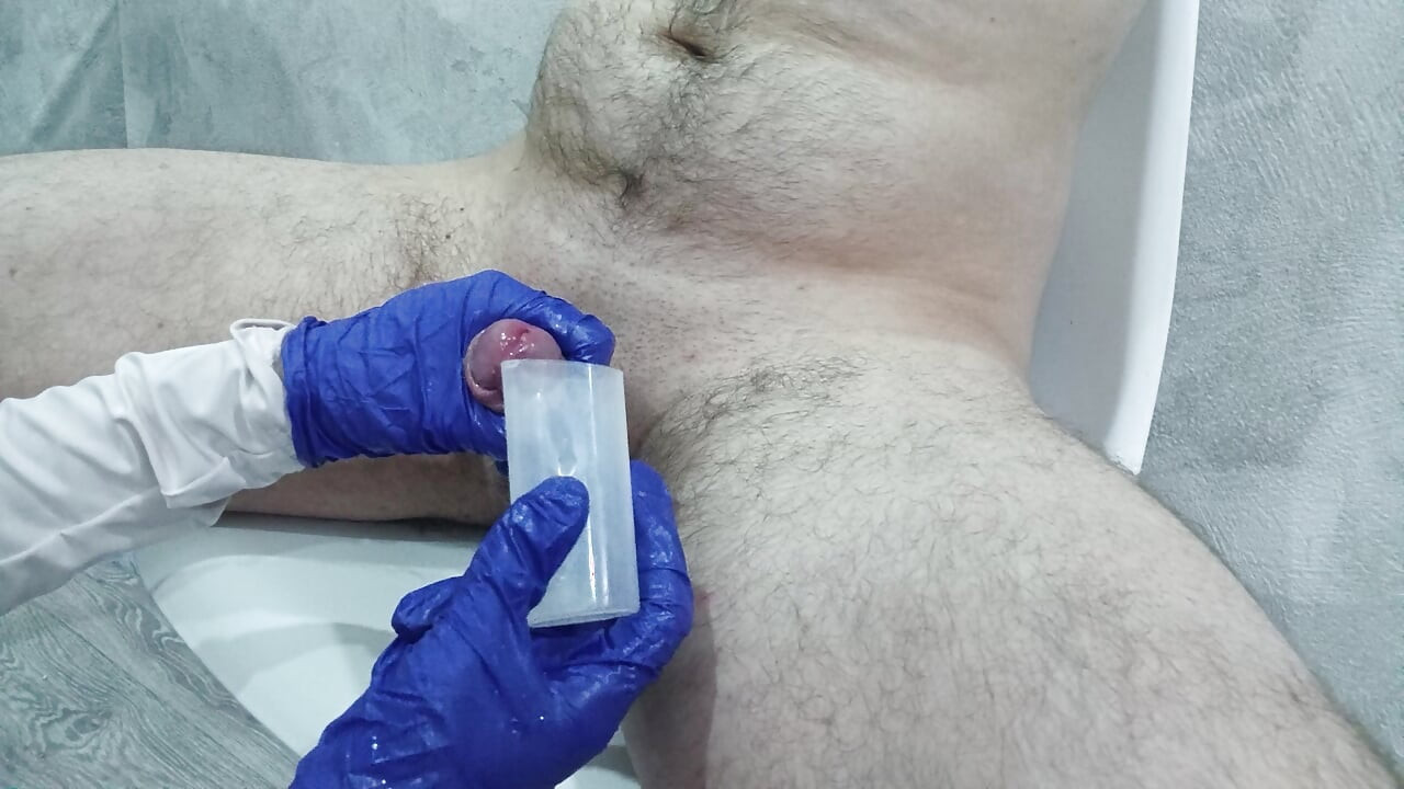 Hemşire analiz için sperm toplamak için hastanın testislerine ve penisine iyice masaj yaptı.