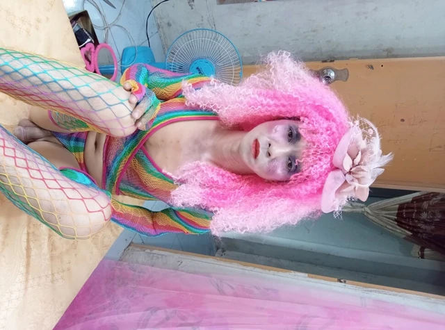 Transgender Le seksi kıyafetler giyiyor ve yapay göğüslerle seks kupaları oynuyor.