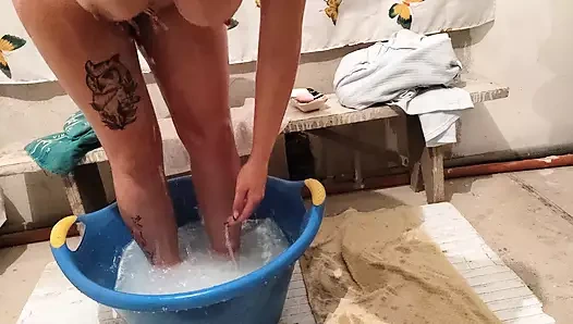 Bir köylü kız işten sonra vücudunu su havzasında yıkıyor