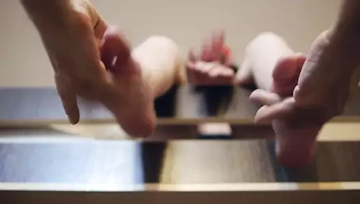 Bir adam sevimli kadın bacaklarına şiddetle müziğe masaj yapıyor.