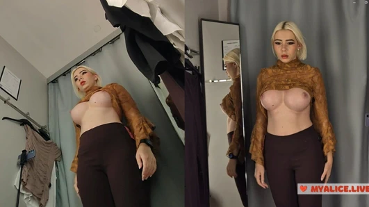 Büyük memeli sarışın alışveriş merkezinde kıyafetlerini deniyor. Soyunma odasında külotsuz orta yaşlı seksi kadın