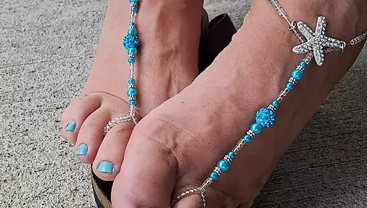 Çıplak ayakla eşleşen sandaletli sevimli, pedikürlü ayaklar