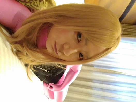 A blonde cross-dressing boy masturbated perverted over pink full-body tights wearing a swimsuit and gloves.