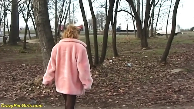 Kızıl saçlı evli kadın açık havada işiyor