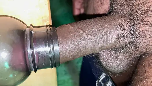 Hintli desi oğlan yarakla şişeyi oynuyor.