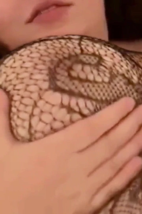 Молодая английская толстушка в костюме-сеточках играет соло в постели