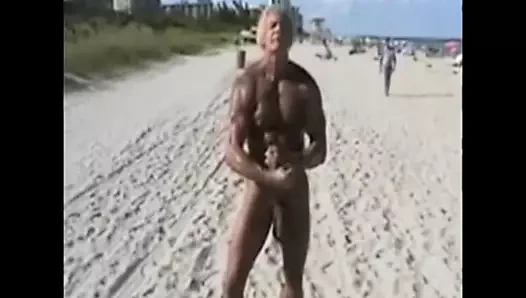 Yaşlı bir adam çıplaklar plajına büyük beyaz bir horoz gösteriyor