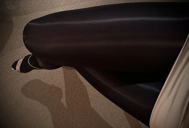 Parlak siyah külotlu çorap katmanları ve parlak altın topuklu ayakkabılar